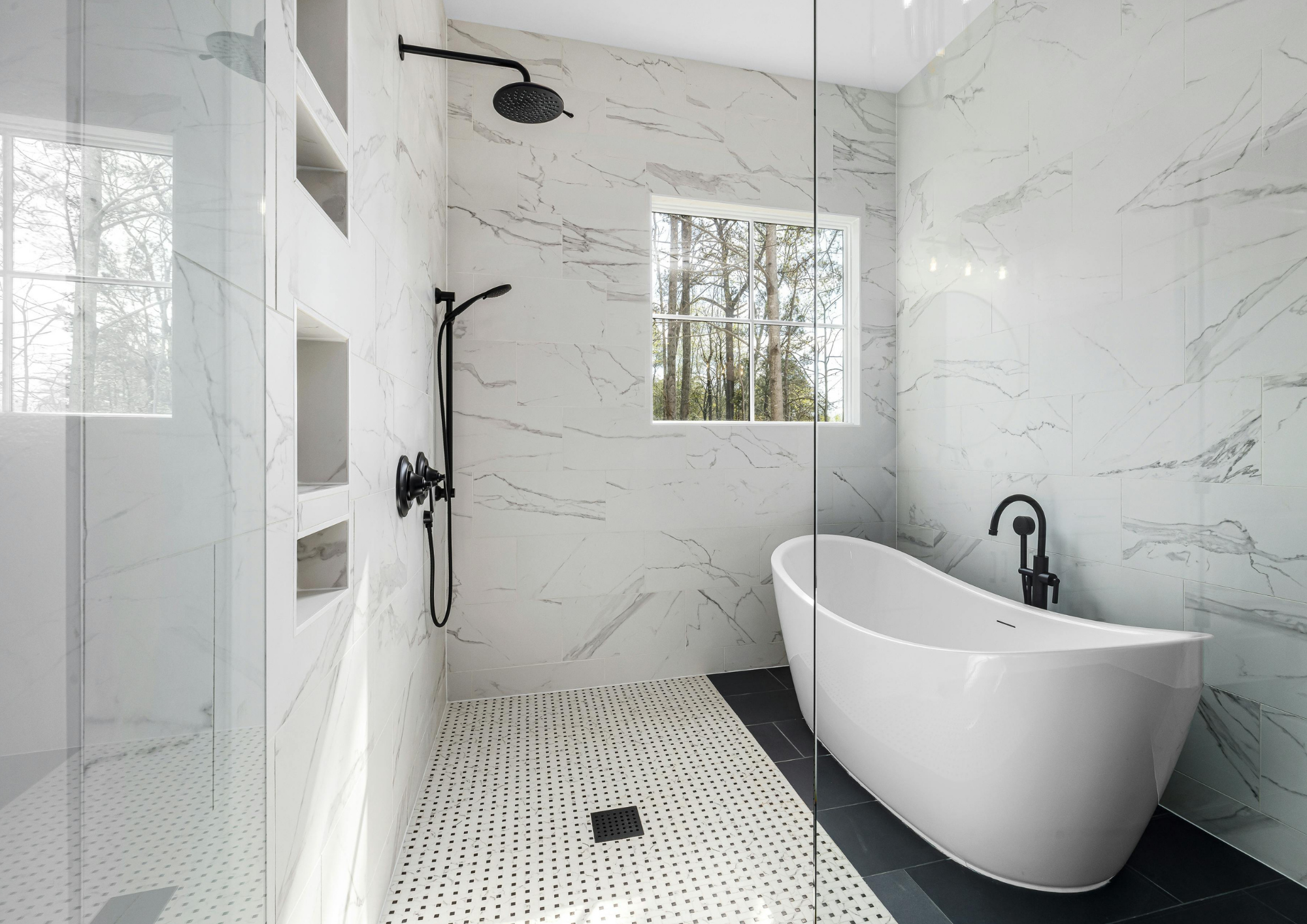 Modernes Badezimmer mit freistehender Badewanne, ebenerdiger Dusche mit schwarzen Armaturen und weißen Marmorwänden